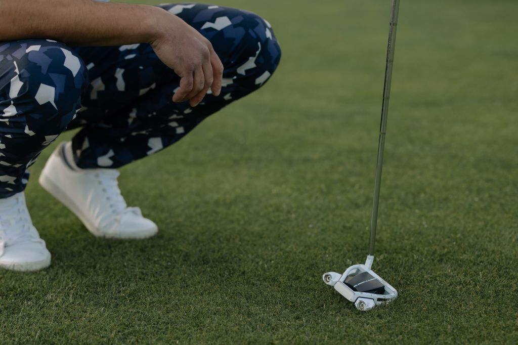 Golfer with putter on golf course